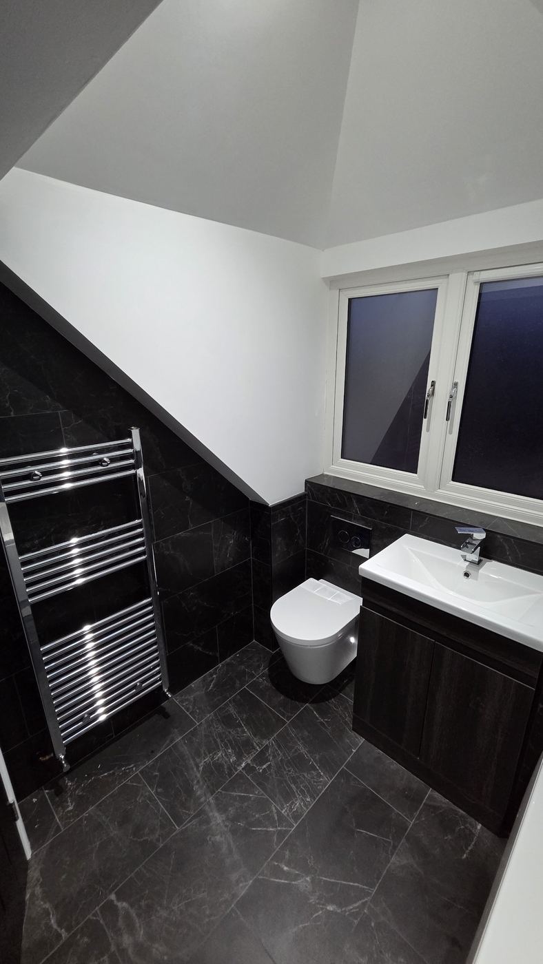 Bathroom under the eaves with marble-effect tiles and wall-hung WC